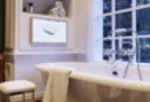 A preview of a white-framed bathroom Ocea style TV on a tiled wall with a bathtub beneath.